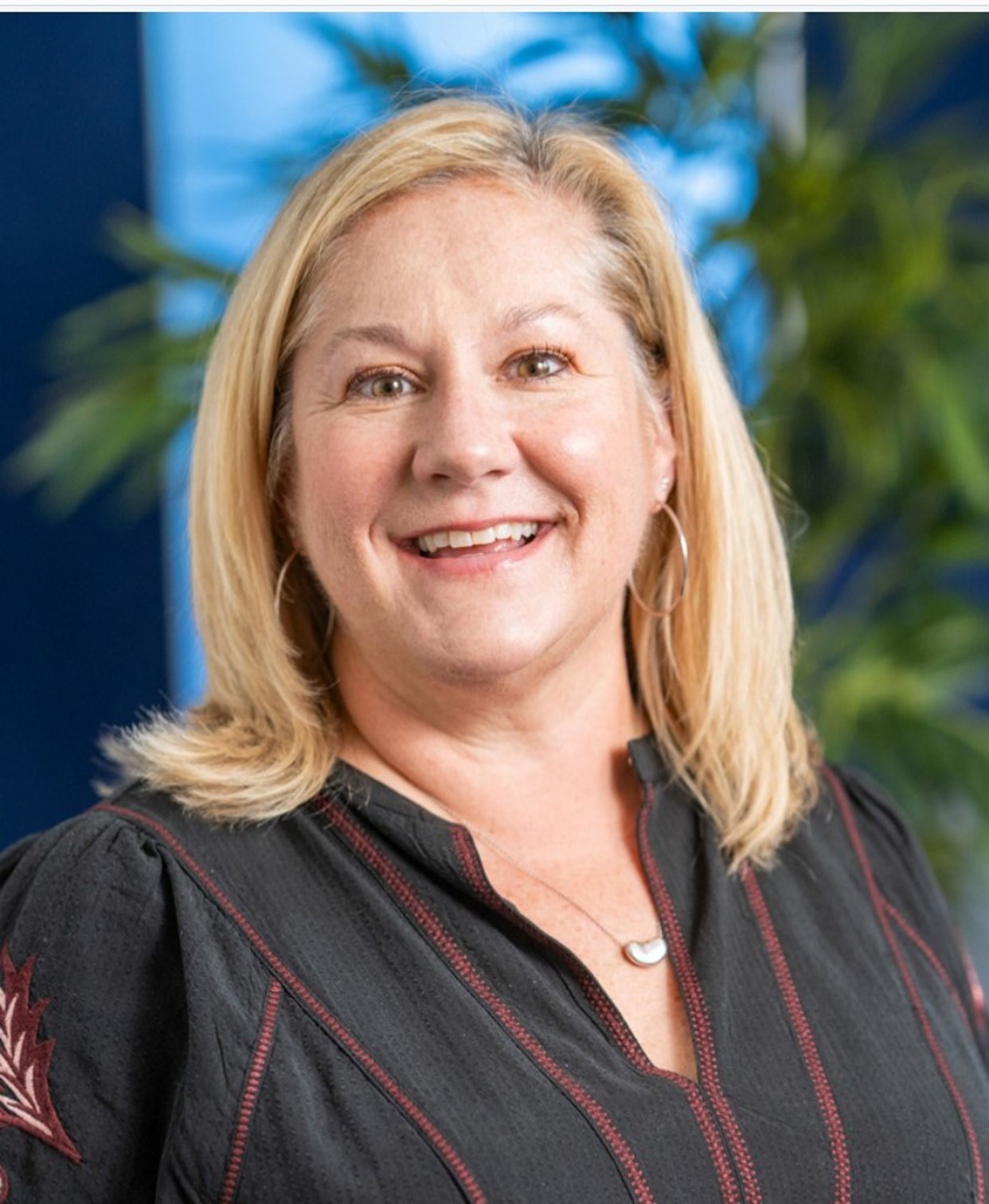 A smiling blond woman in a portrait-style photo.